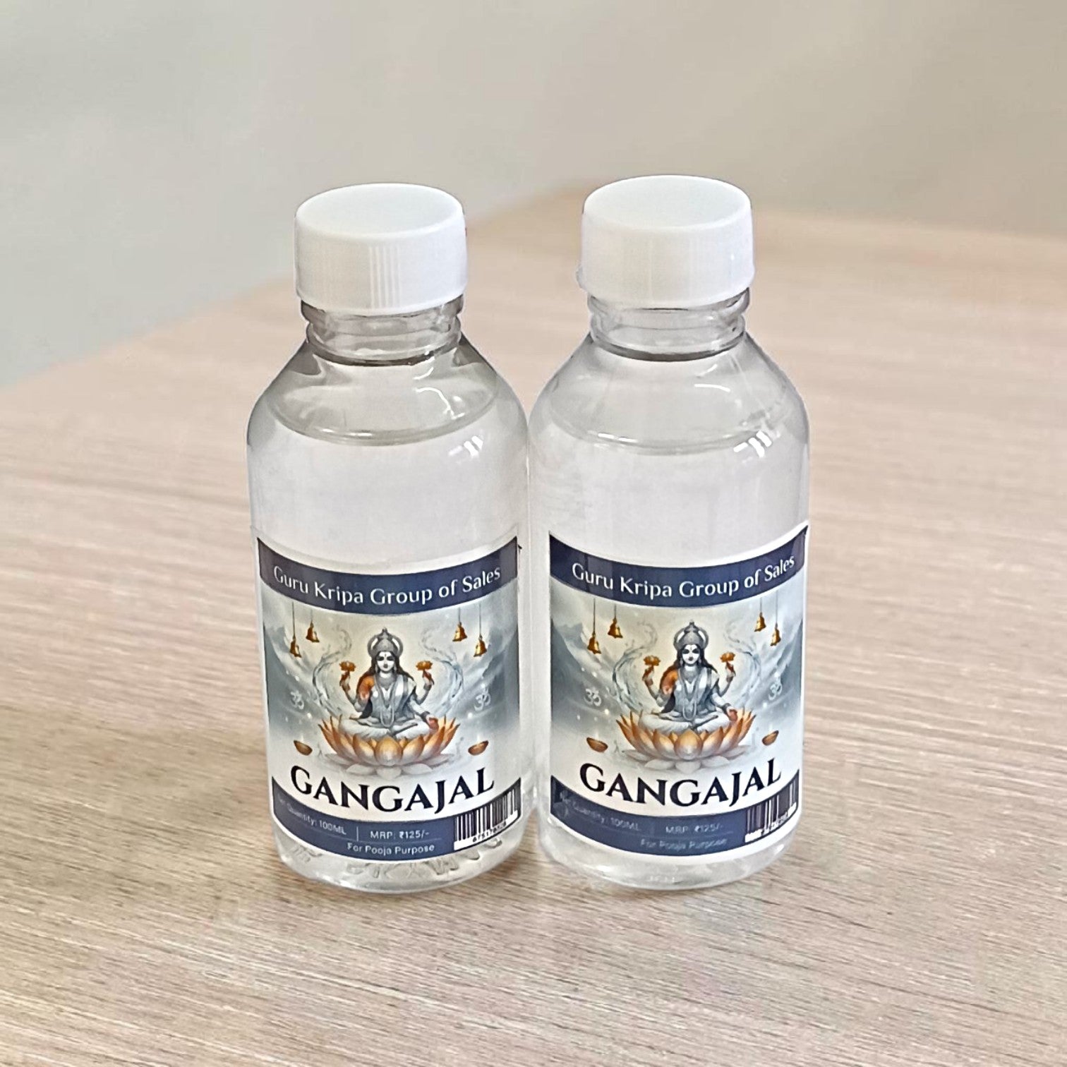 A set of two 100g bottles of Pure Gangajal Holy Water placed side by side, labeled for pooja and spiritual use