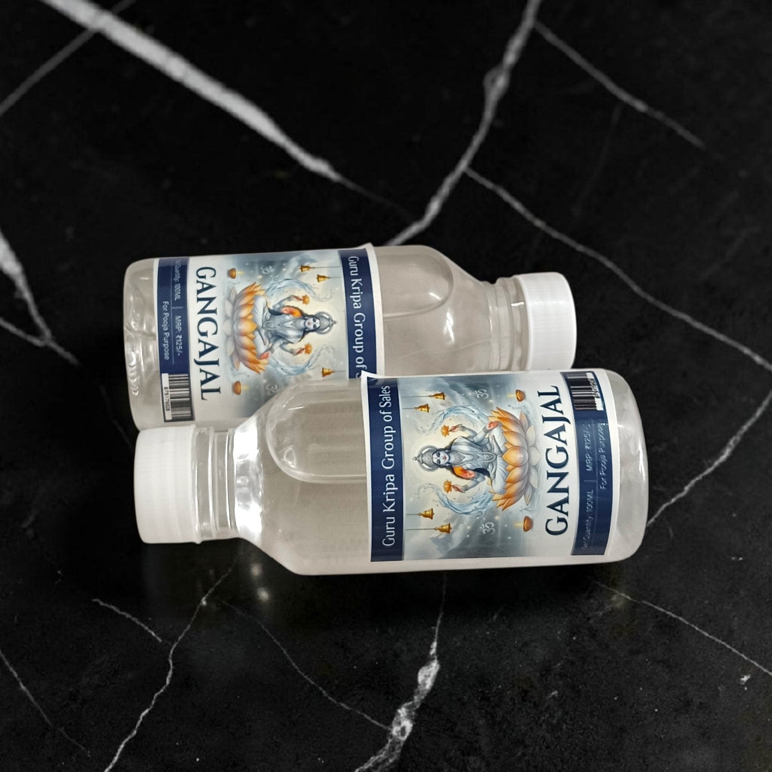 A set of two 100g bottles of Pure Gangajal Holy Water placed side by side, labeled for pooja and spiritual use