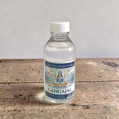A set of two 100g bottles of Pure Gangajal Holy Water placed side by side, labeled for pooja and spiritual use