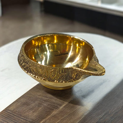 A small 2-inch brass oil lamp with a heavy base, perfect for pooja, festivals, and temple use, featuring a traditional design for stability during rituals.