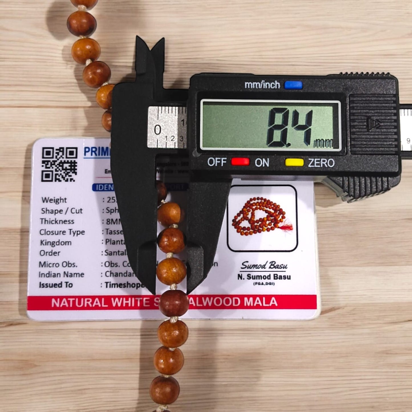A traditional White Sandalwood Mala (Safed Chandan Mala) made with 108+1 beads, displayed with a sacred backdrop