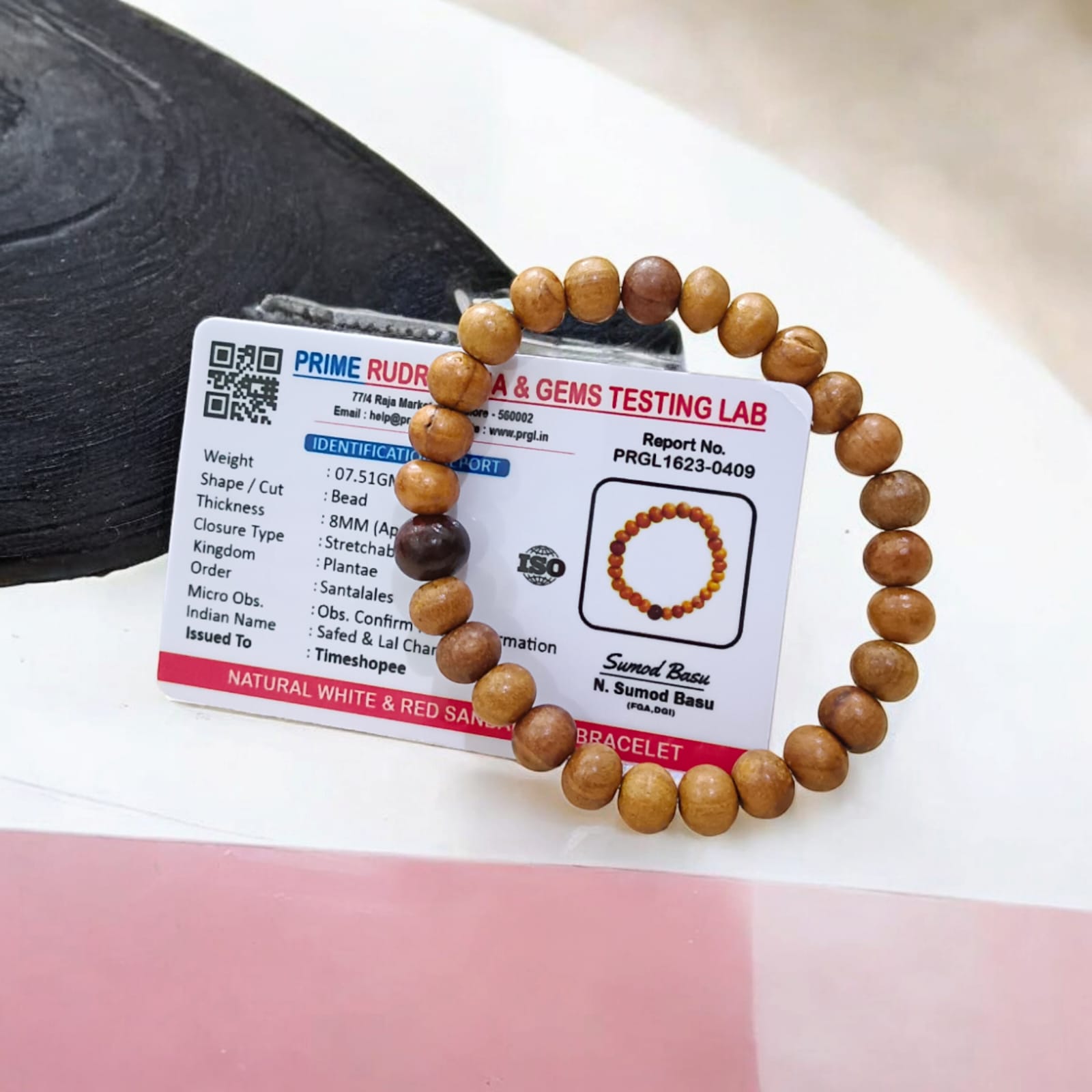 A beautiful Red & White Sandalwood Bracelet with 8MM lab-certified beads, showcasing its elegant design and spiritual significance.