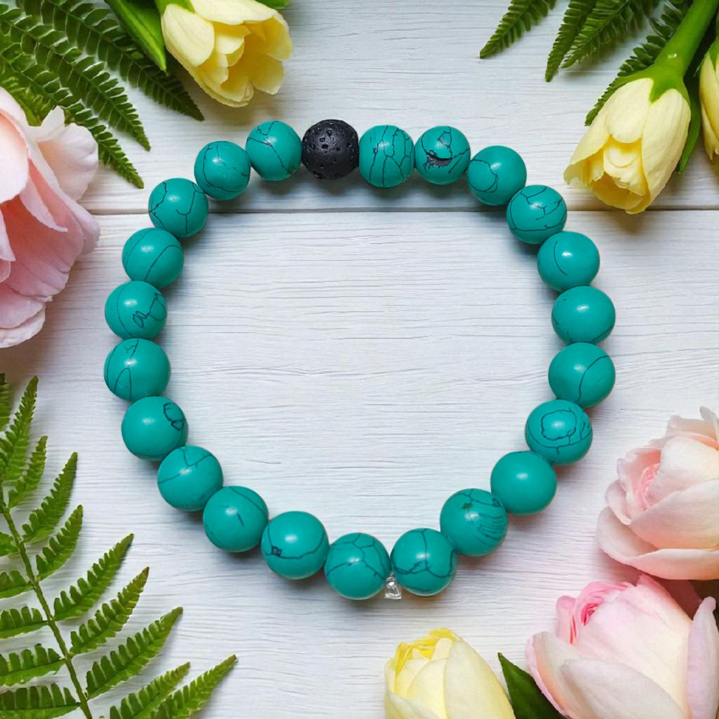 Bracelet made of 8mm natural turquoise and black lava stone beads, arranged on stretchable thread and displayed on a minimal, clean background