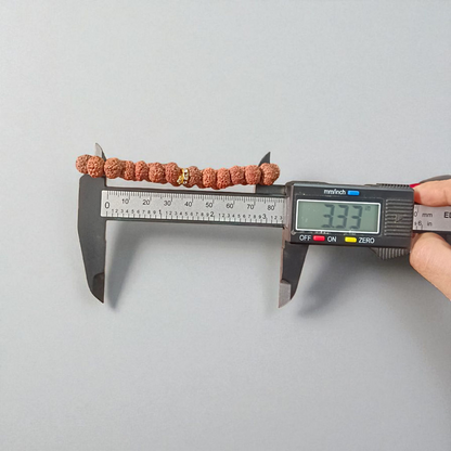 Image of 7 Mukhi Rudraksha Bracelet with 9mm natural brown beads, arranged in a stretchable circular form, set against a neutral background