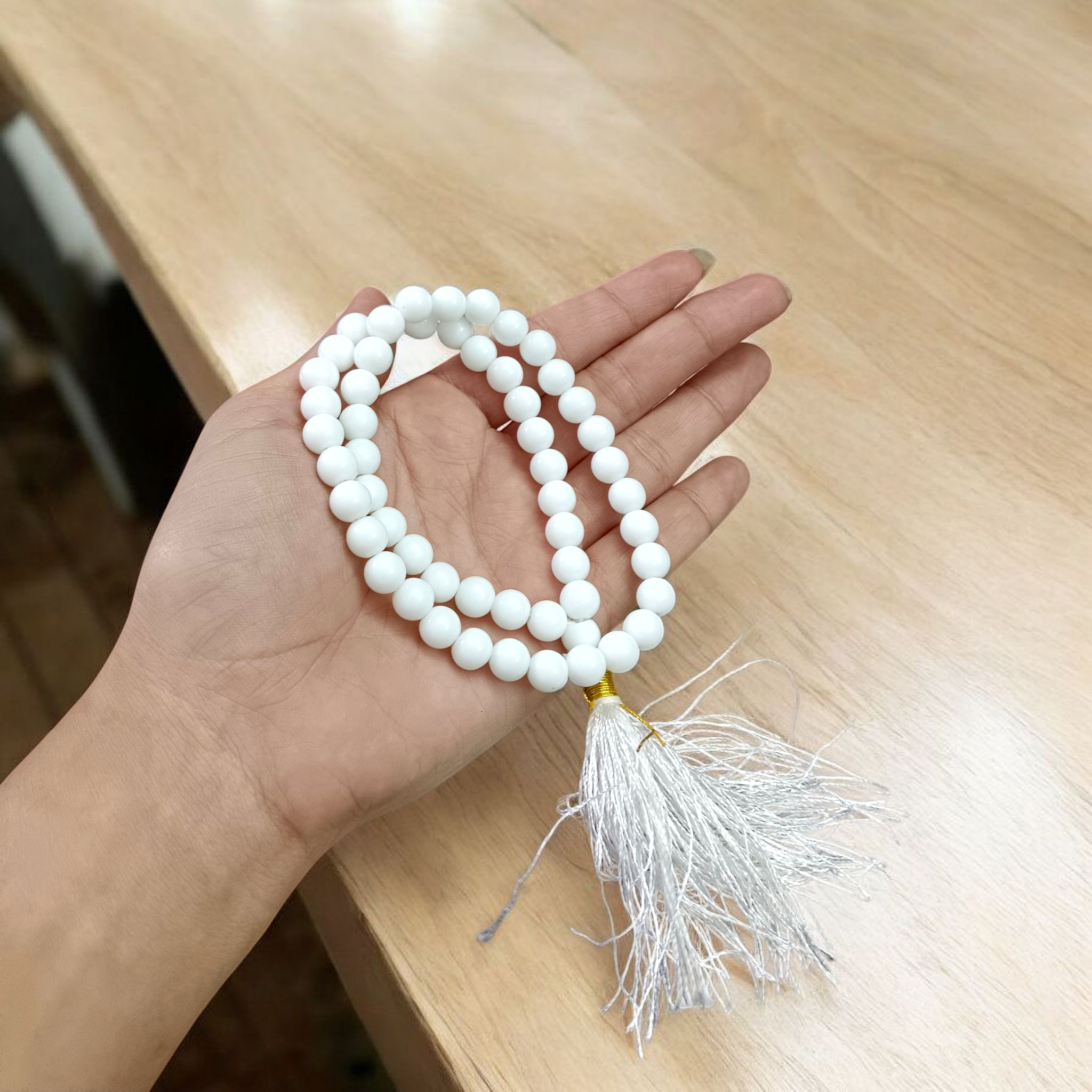 Image of White Agate Mala with 54+1 smooth 8mm Safed Hakik beads, neatly arranged for jaap, meditation, and emotional balance, on a soft spiritual background