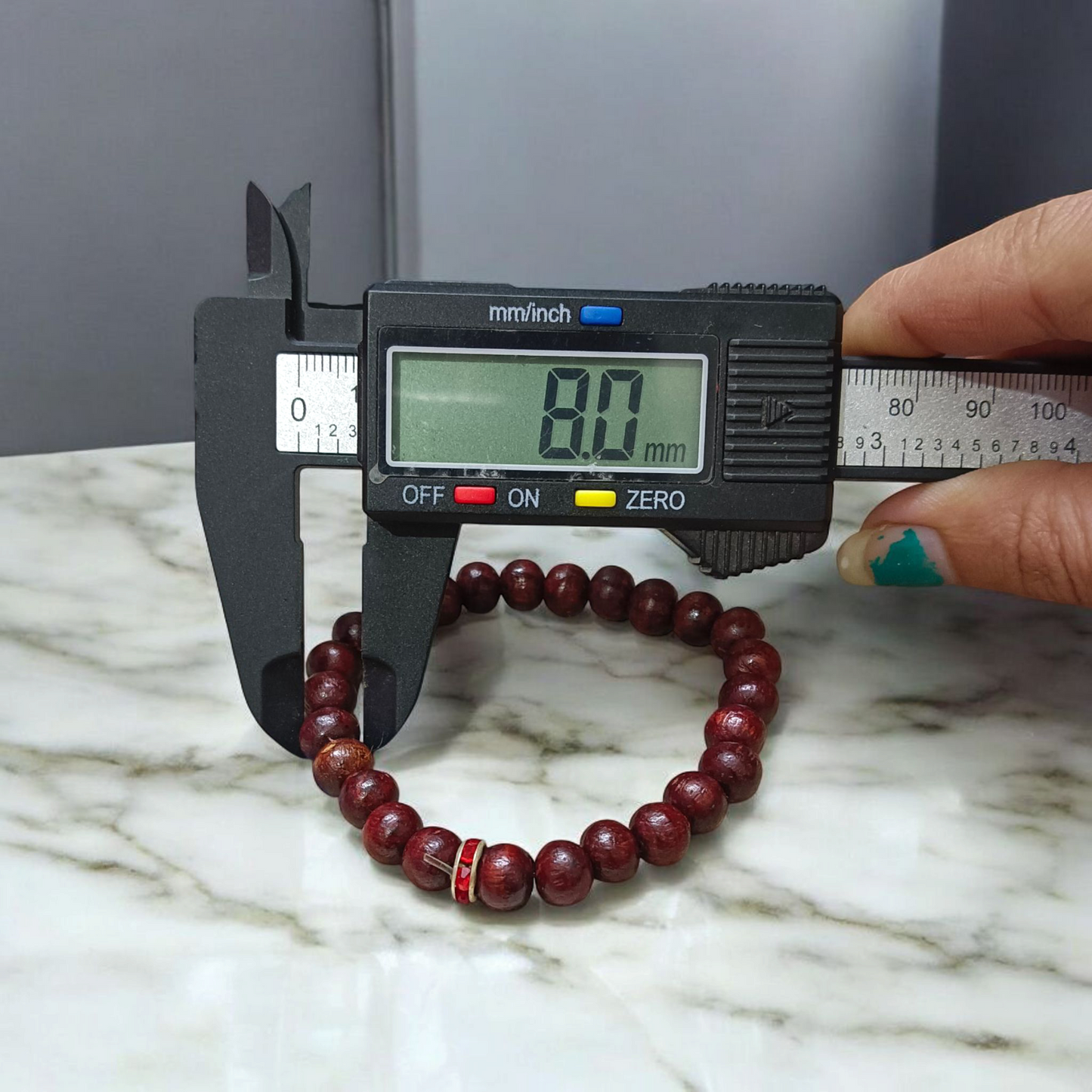Image of a stretchable bracelet made with 8mm natural red sandalwood (Lal Chandan) beads, neatly arranged on a flat neutral background