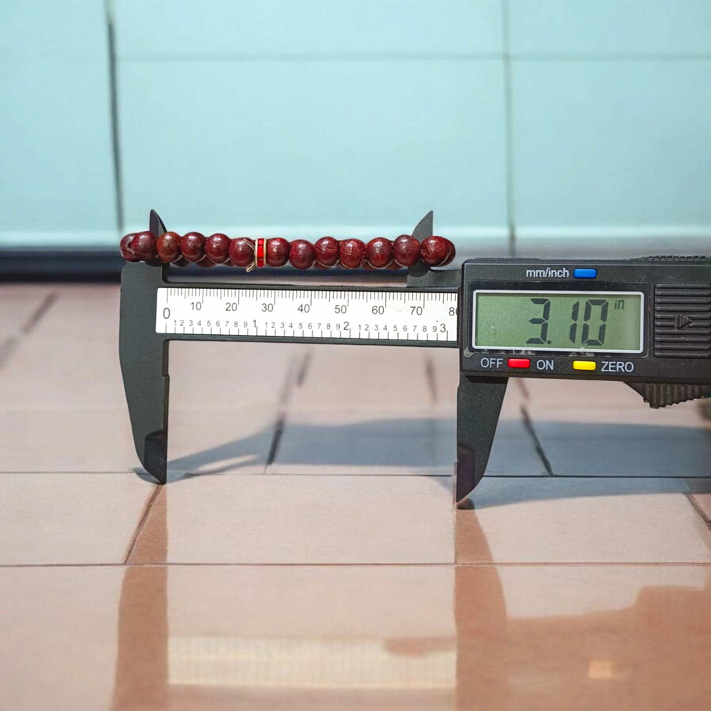 Image of a stretchable bracelet made with 8mm natural red sandalwood (Lal Chandan) beads, neatly arranged on a flat neutral background
