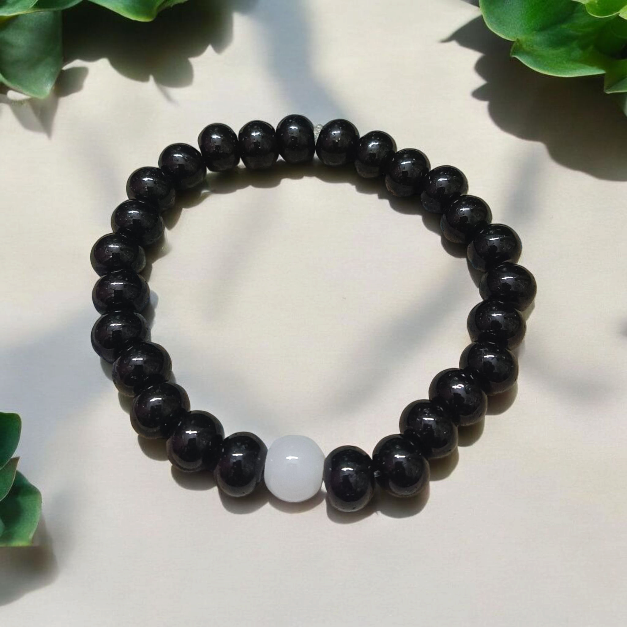 Image showing a stretchable bracelet made of 8mm natural black and white agate beads, arranged in alternating pattern, displayed on a neutral background