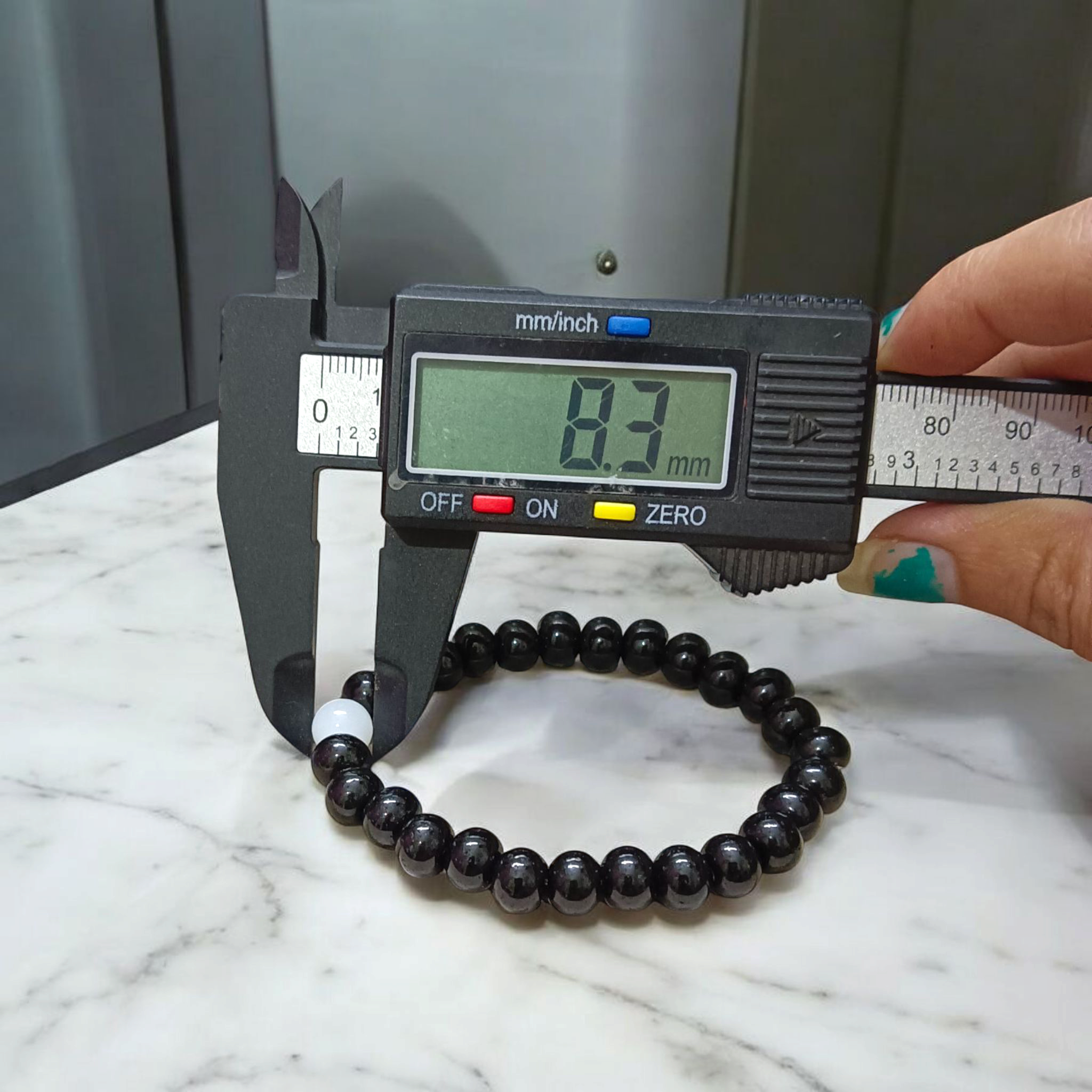 Image showing a stretchable bracelet made of 8mm natural black and white agate beads, arranged in alternating pattern, displayed on a neutral background