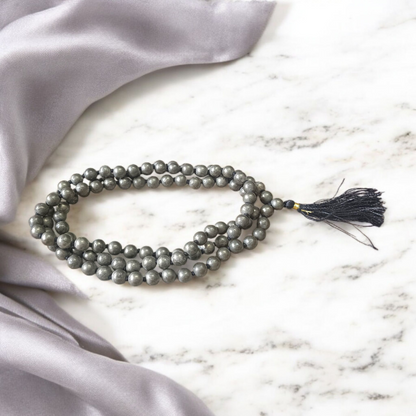Lab-certified Natural Raw Pyrite Mala (108+1 beads, 8MM) with metallic golden finish, placed on a white background with spiritual packaging