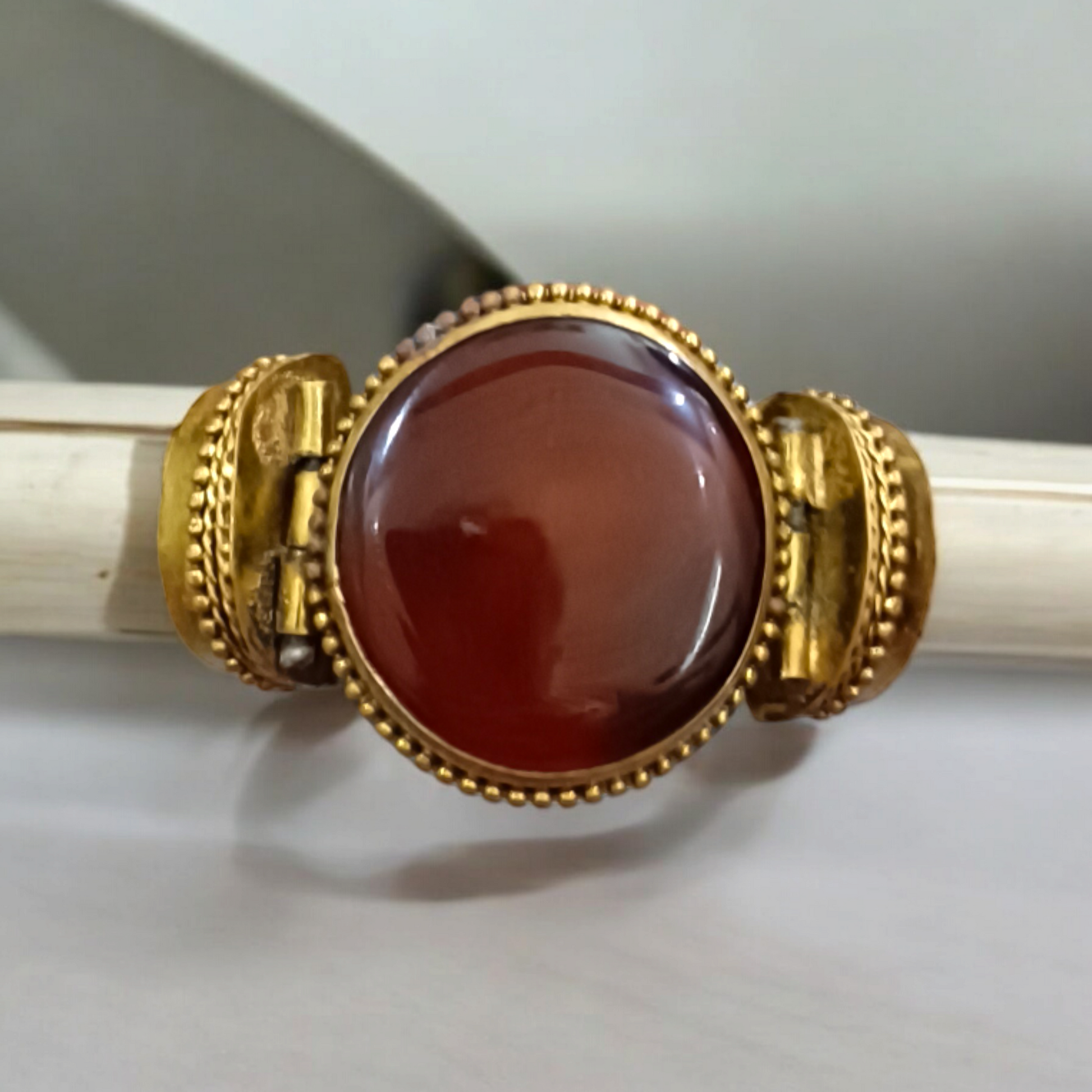 Lal Hakik Bracelet featuring red agate stone set in antique brass cuff, accompanied by lab certificate.