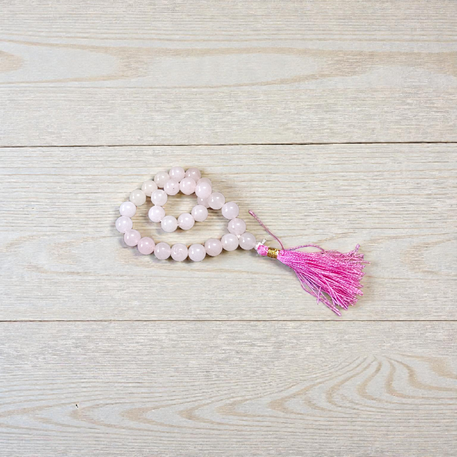 Natural Rose Quartz Mala with 8mm pink beads arranged neatly for meditation and spiritual use