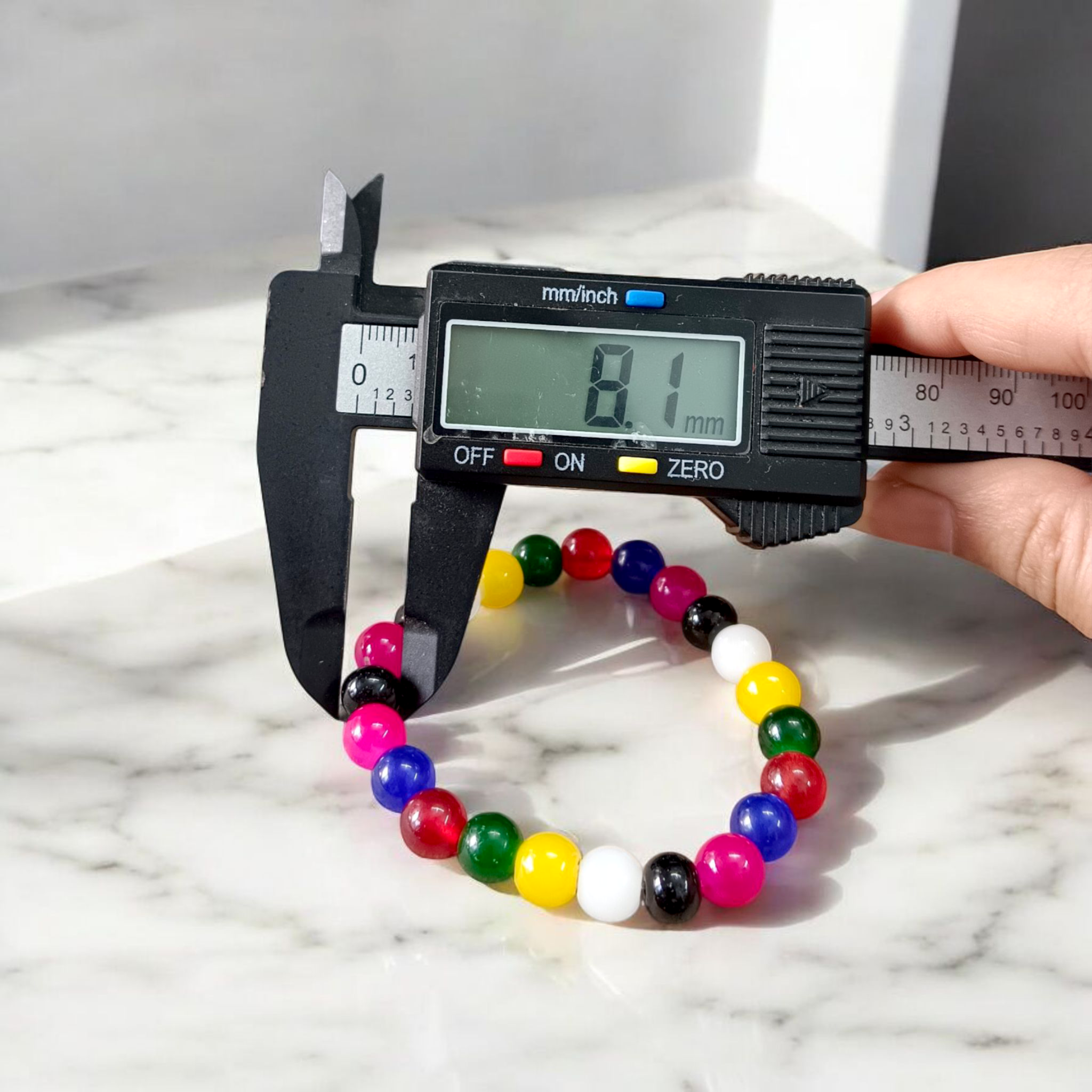 Natural multicolor agate (Hakik) bracelet made with 8mm round beads on a stretchable string, displayed on a neutral background