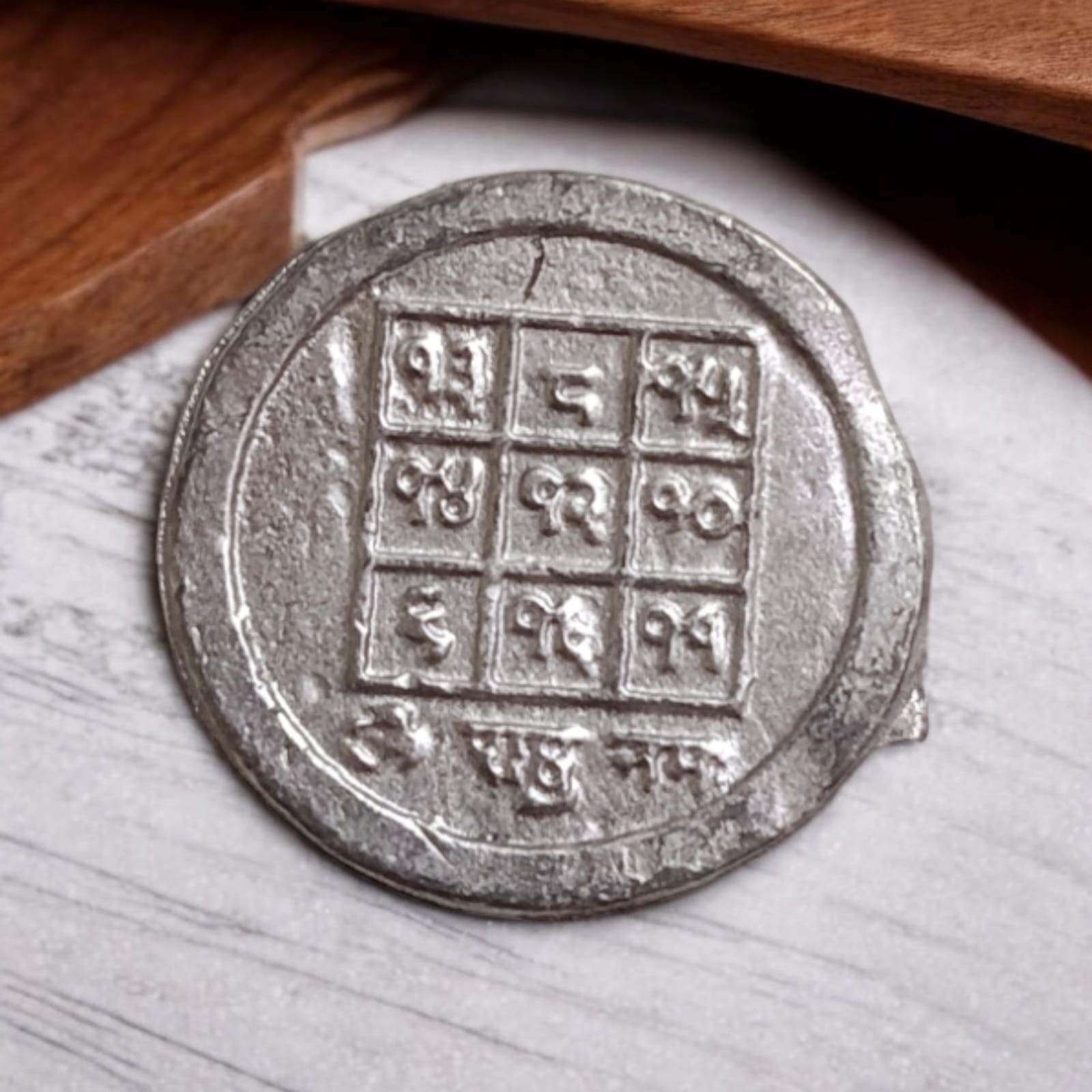 Ranga Rahu Yantra Coin featuring intricate designs, used for remedies against Rahu’s malefic effects, suitable for carrying or placement in home or office.