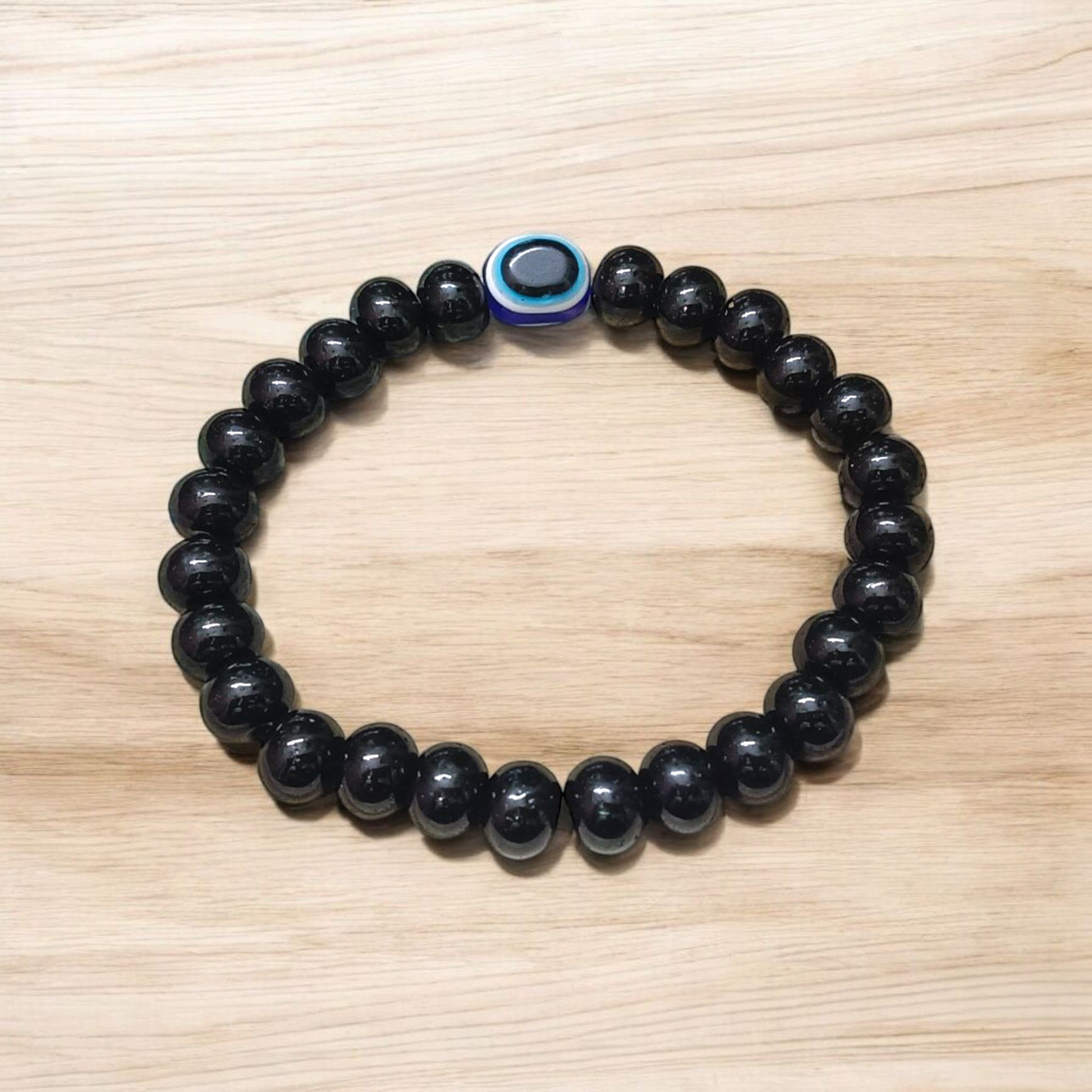 Stretchable Black Obsidian Bracelet made with natural 8mm beads, placed on a light background, highlighting its glossy finish