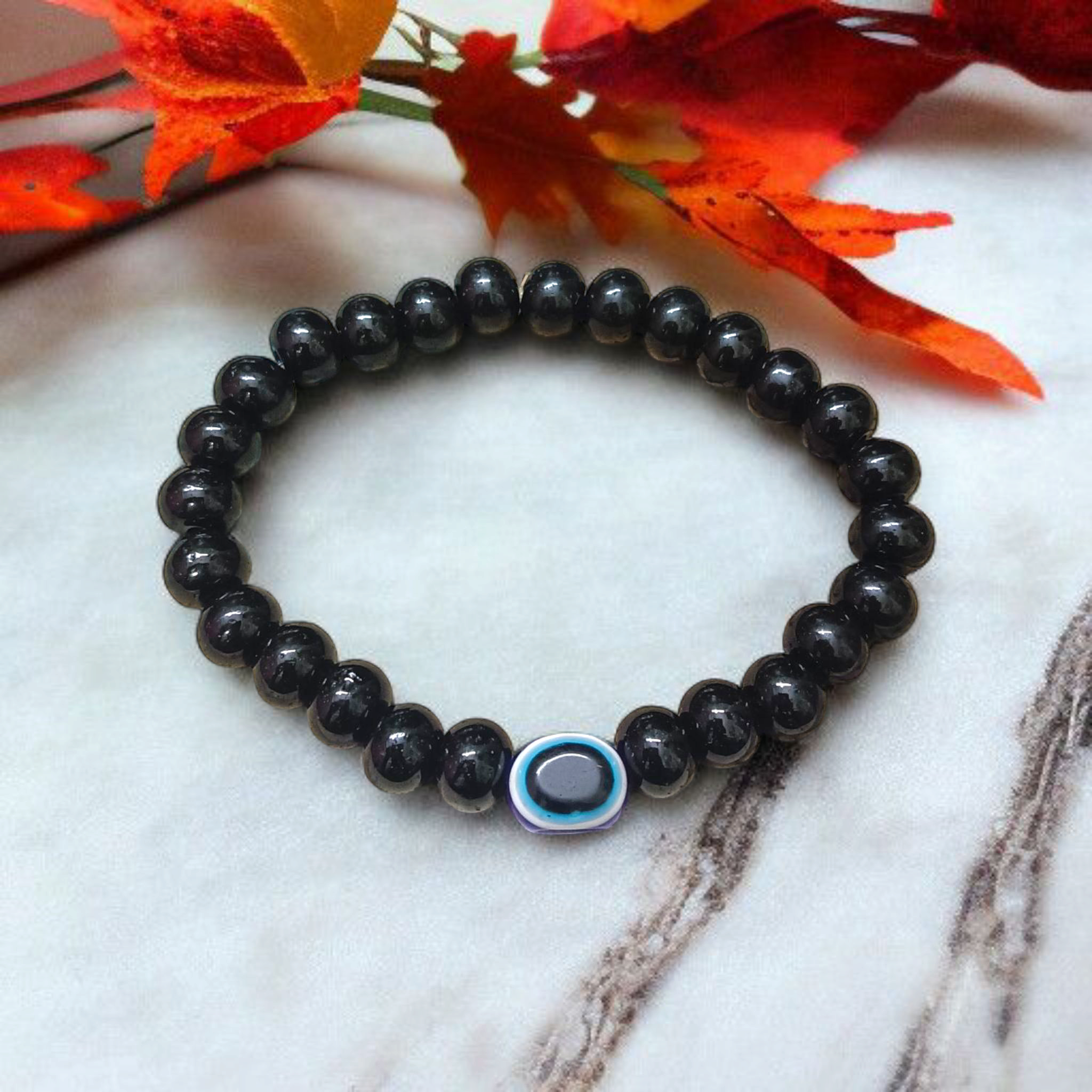 Stretchable Black Obsidian Bracelet made with natural 8mm beads, placed on a light background, highlighting its glossy finish