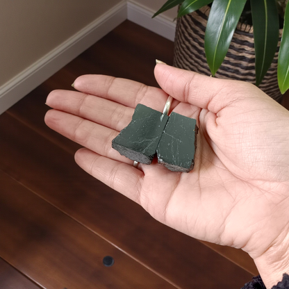 Two polished black Tourmaline stones with smooth texture, placed side by side, symbolizing protection, grounding, and Root Chakra energy