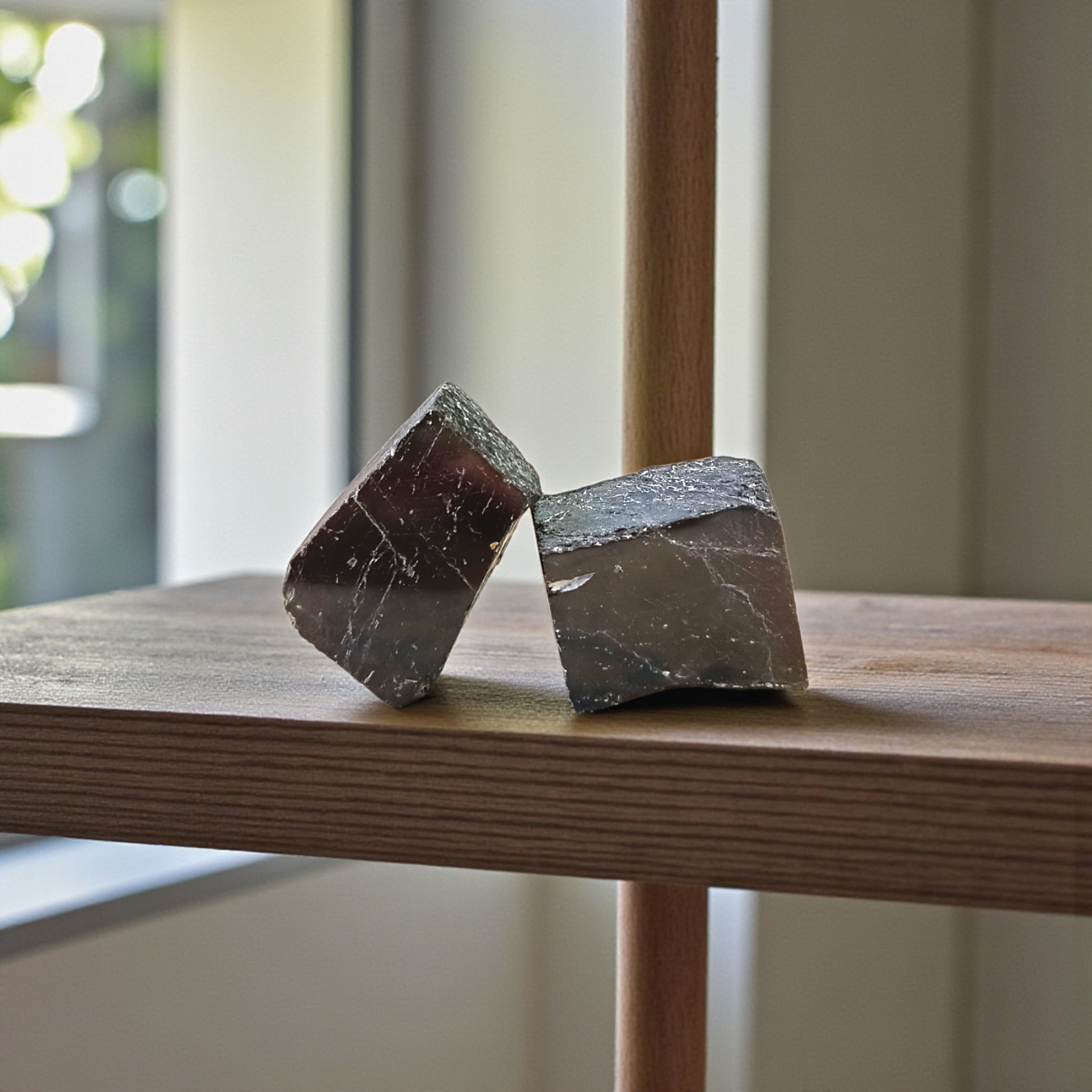 Two polished black Tourmaline stones with smooth texture, placed side by side, symbolizing protection, grounding, and Root Chakra energy