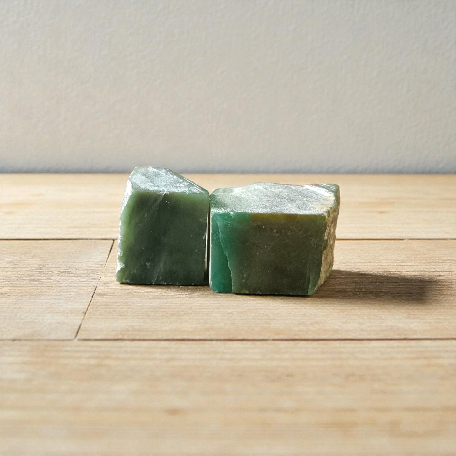 Two polished green Aventurine stones placed side by side, showcasing their smooth texture and natural crystal shine