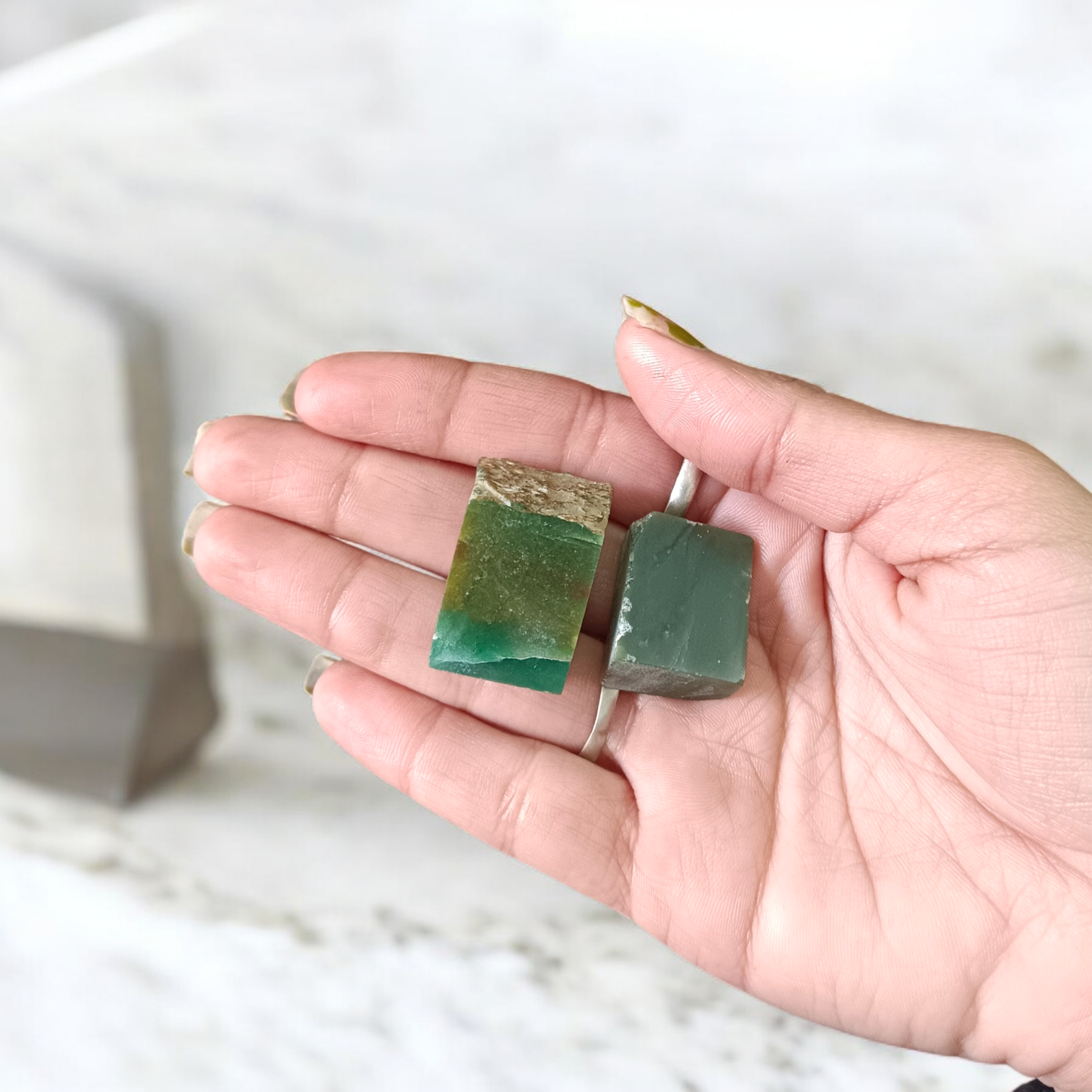 Two polished green Aventurine stones placed side by side, showcasing their smooth texture and natural crystal shine