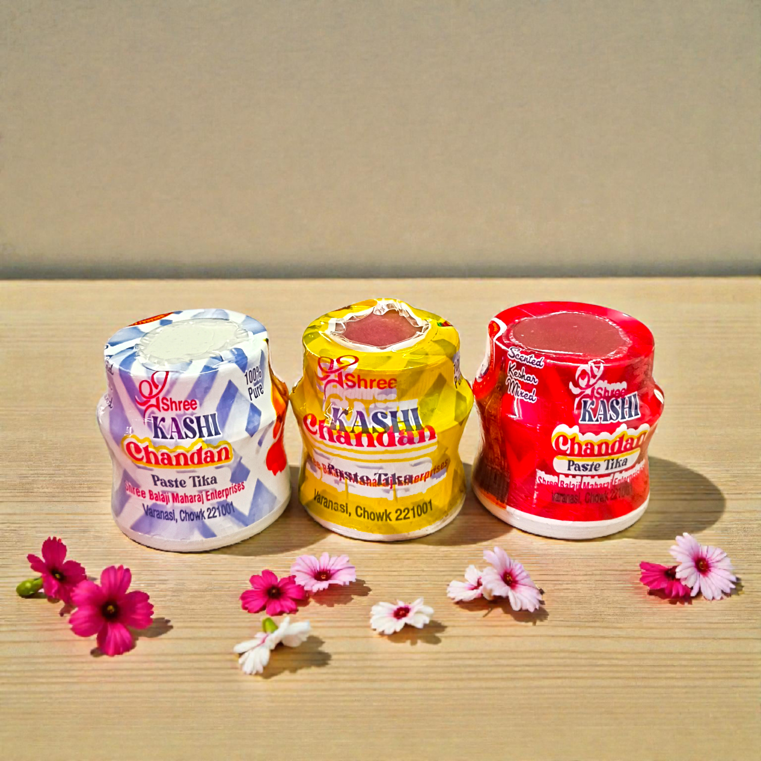 Yellow, red, and white chandan paste containers used for tilak and puja