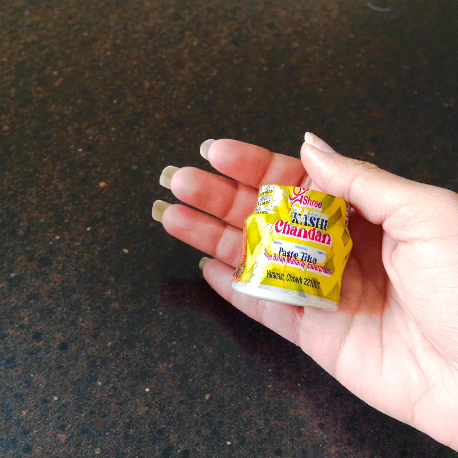 Yellow, red, and white chandan paste containers used for tilak and puja